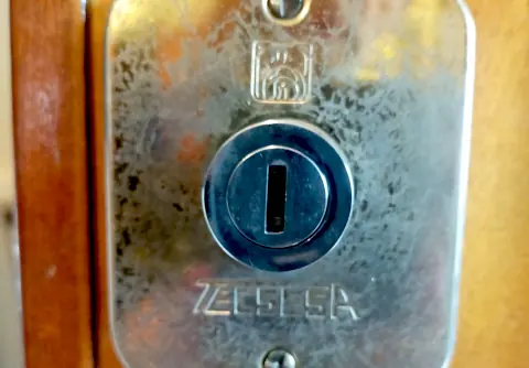 Placa de una cerradura de seguridad antigua en una puerta de madera