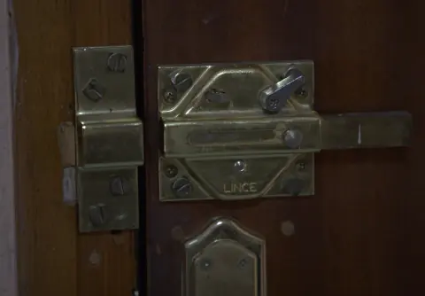 Cerrojo de seguridad Lince de sobreponer instalado en una puerta de madera
