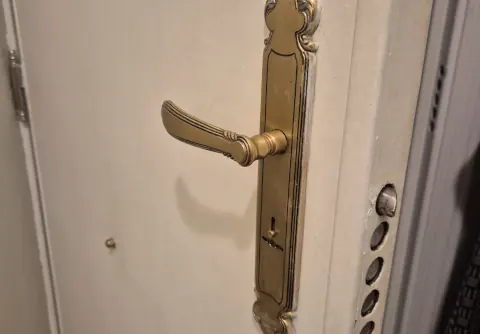 Puerta con manilla de placa larga y cerradero con varios puntos de anclaje en el marco